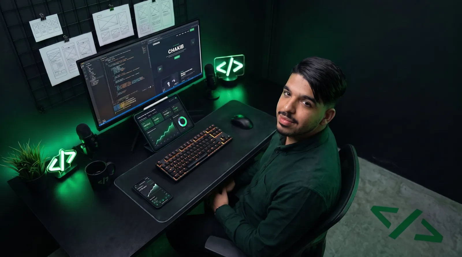 Mohamed Chakib at his desk, in front of his code screen and wireframes